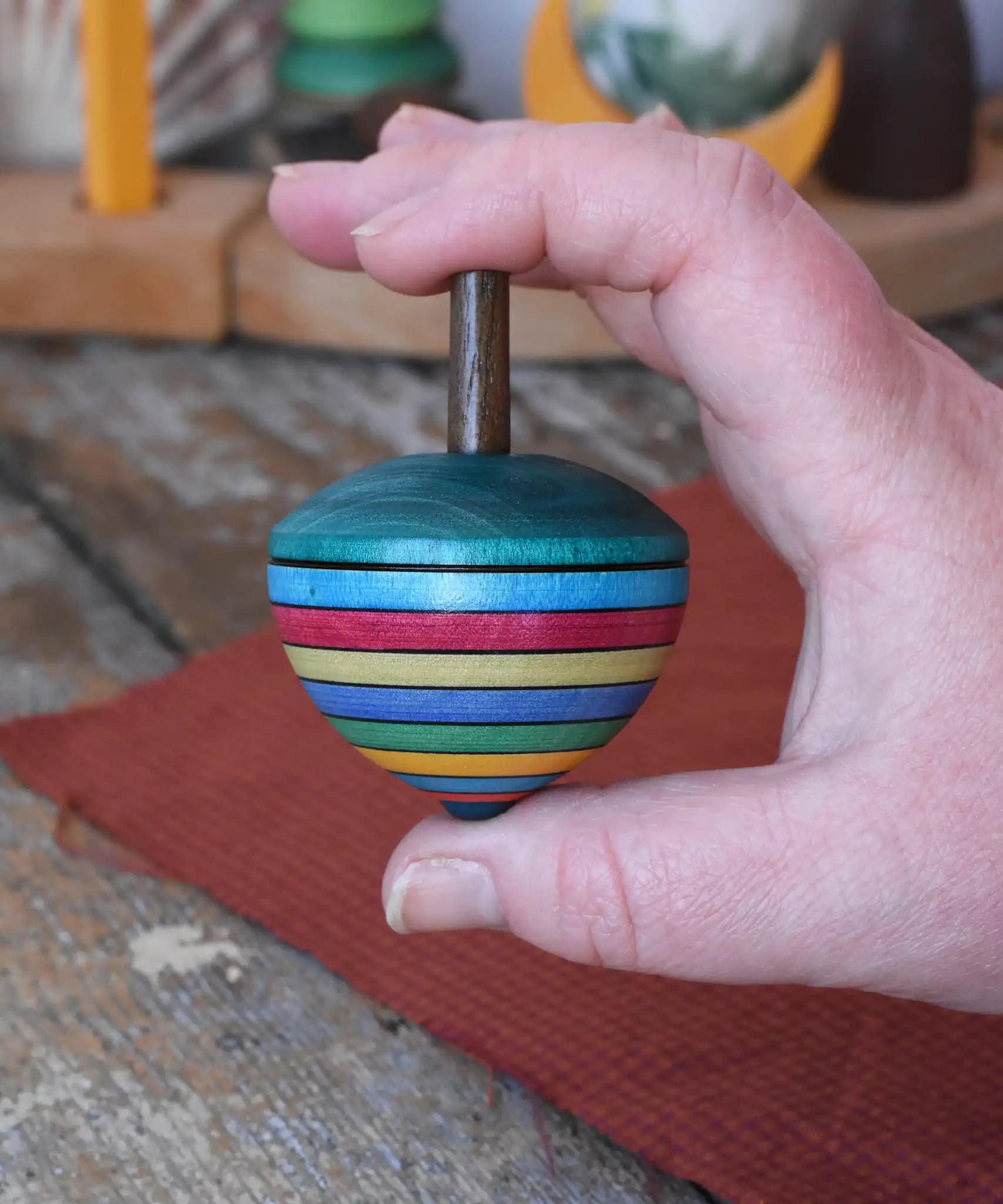Mader dragon egg spinning top placed in an adult hand.