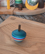 Mader dragon egg spinning top spinning in motion on an oak spinning plate in the Babipur playroom. 