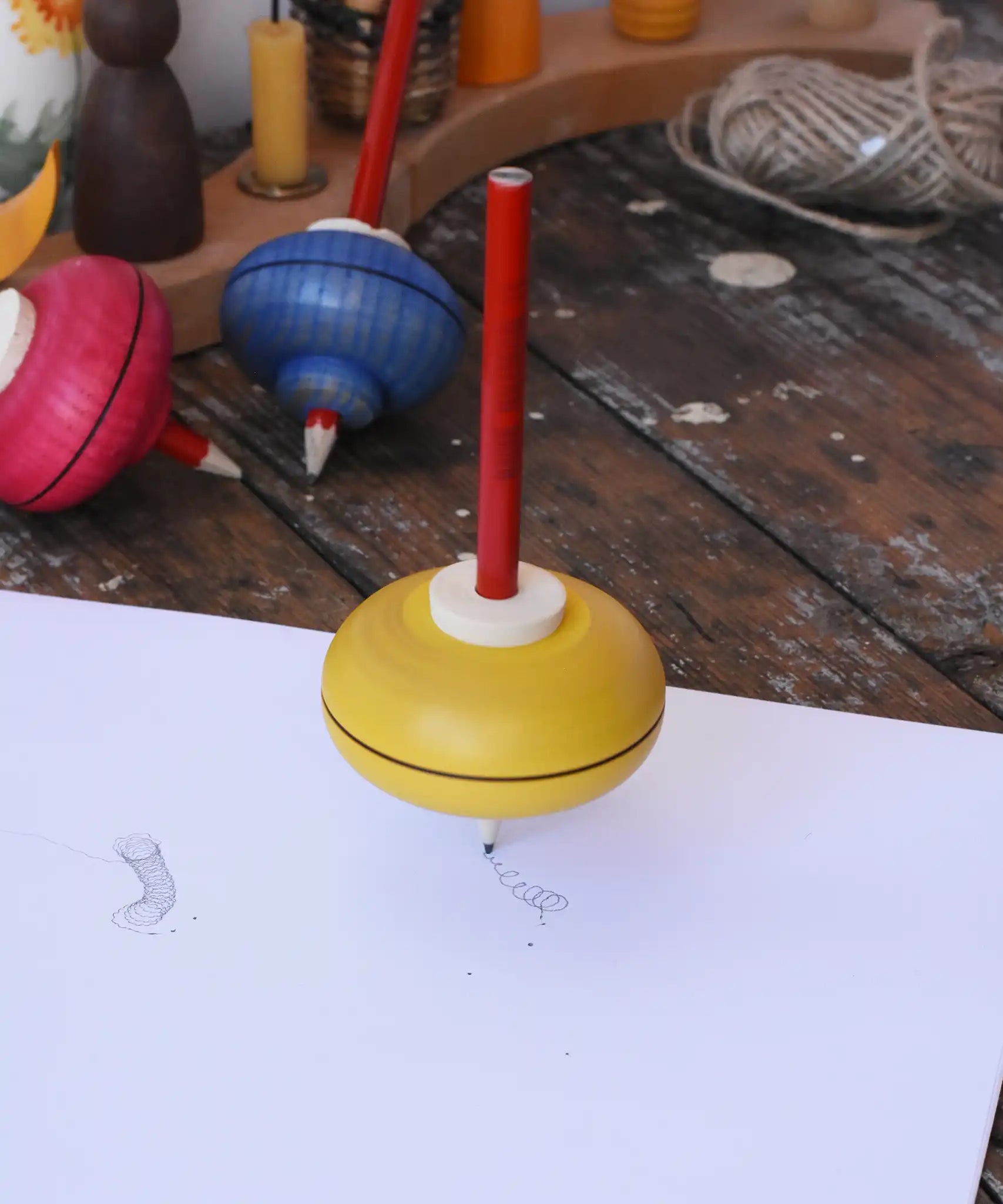 Mader Drawing spinning top spinning in motion on paper creating spin marks in the Babipur playroom.