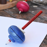 Mader Drawing spinning top in blue placed on paper in the Babipur playroom.
