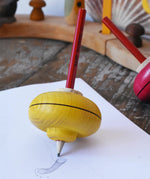 Mader Drawing spinning top placed on paper which has pencil marks on in the Babipur playroom.