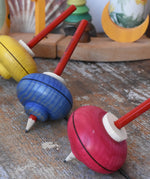 Mader Drawing spinning tops placed on a wooden desk in the Babipur playroom.