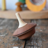 Mader duet spinning top wooden toy placed on a wooden surface in the Babipur playroom.