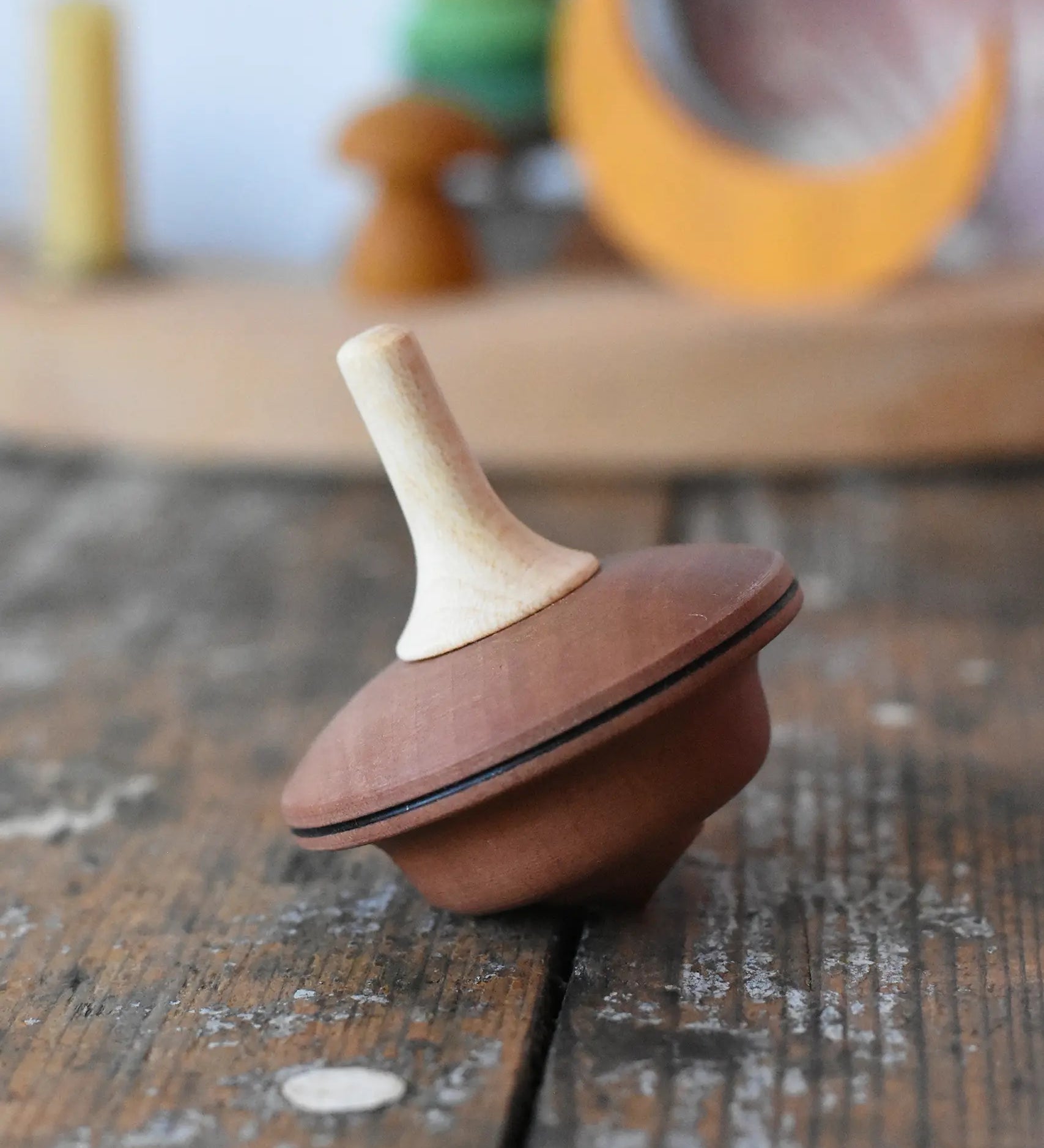 Mader duet spinning top wooden toy placed on a wooden surface in the Babipur playroom.