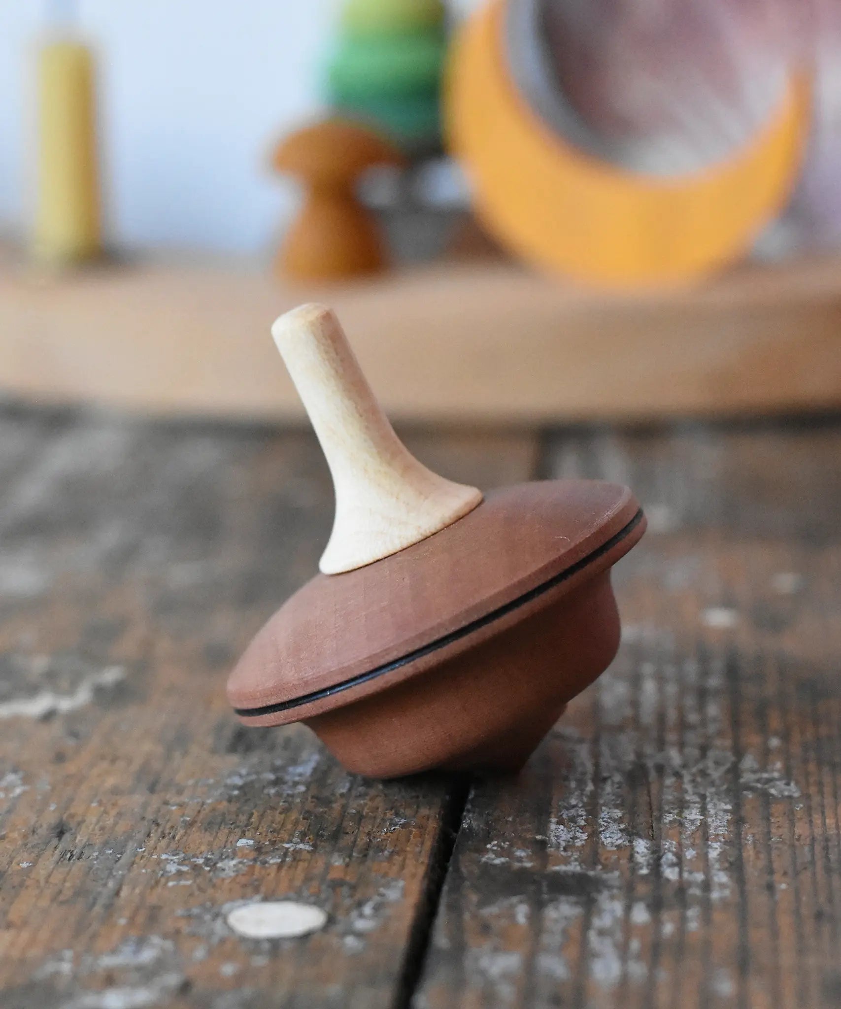 Mader duet spinning top wooden toy placed on a wooden surface in the Babipur playroom.
