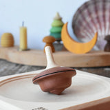 Mader duet spinning top wooden toy placed on a medium maple spinning plate.