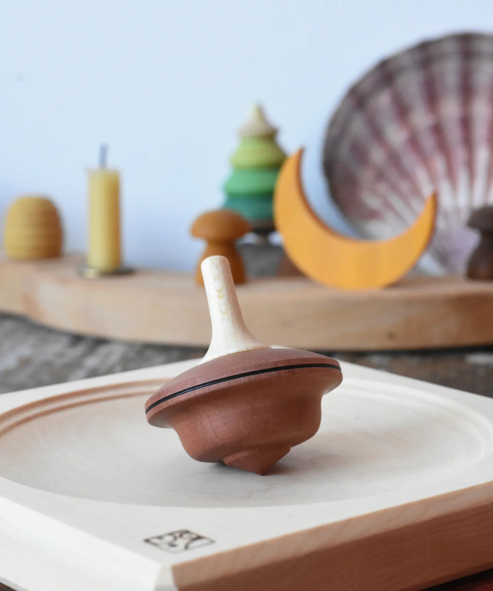 Mader duet spinning top wooden toy placed on a medium maple spinning plate.