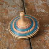 Blue Mader Kreiselmanufaktur fado maple wooden finger spinning top placed on a wooden surface in the Babipur playroom.