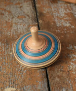 Blue Mader Kreiselmanufaktur fado maple wooden finger spinning top placed on a wooden surface in the Babipur playroom.