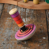Mader my first spinning top toy with starter in pink placed on a wooden surface in the Babipur playroom. 