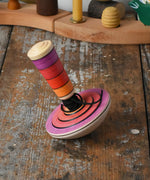 Mader my first spinning top toy with starter in pink placed on a wooden surface in the Babipur playroom. 