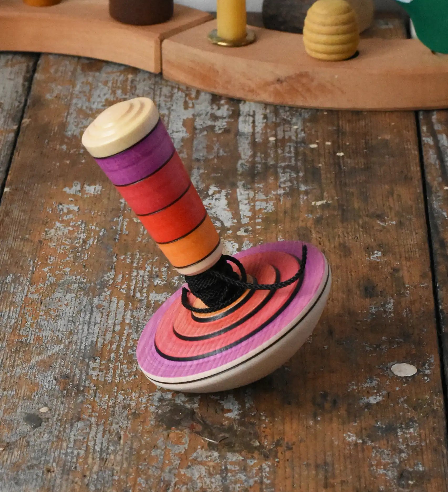 Mader my first spinning top toy with starter in pink placed on a wooden surface in the Babipur playroom. 