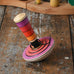 Mader my first spinning top toy with starter in pink placed on a wooden surface in the Babipur playroom. 