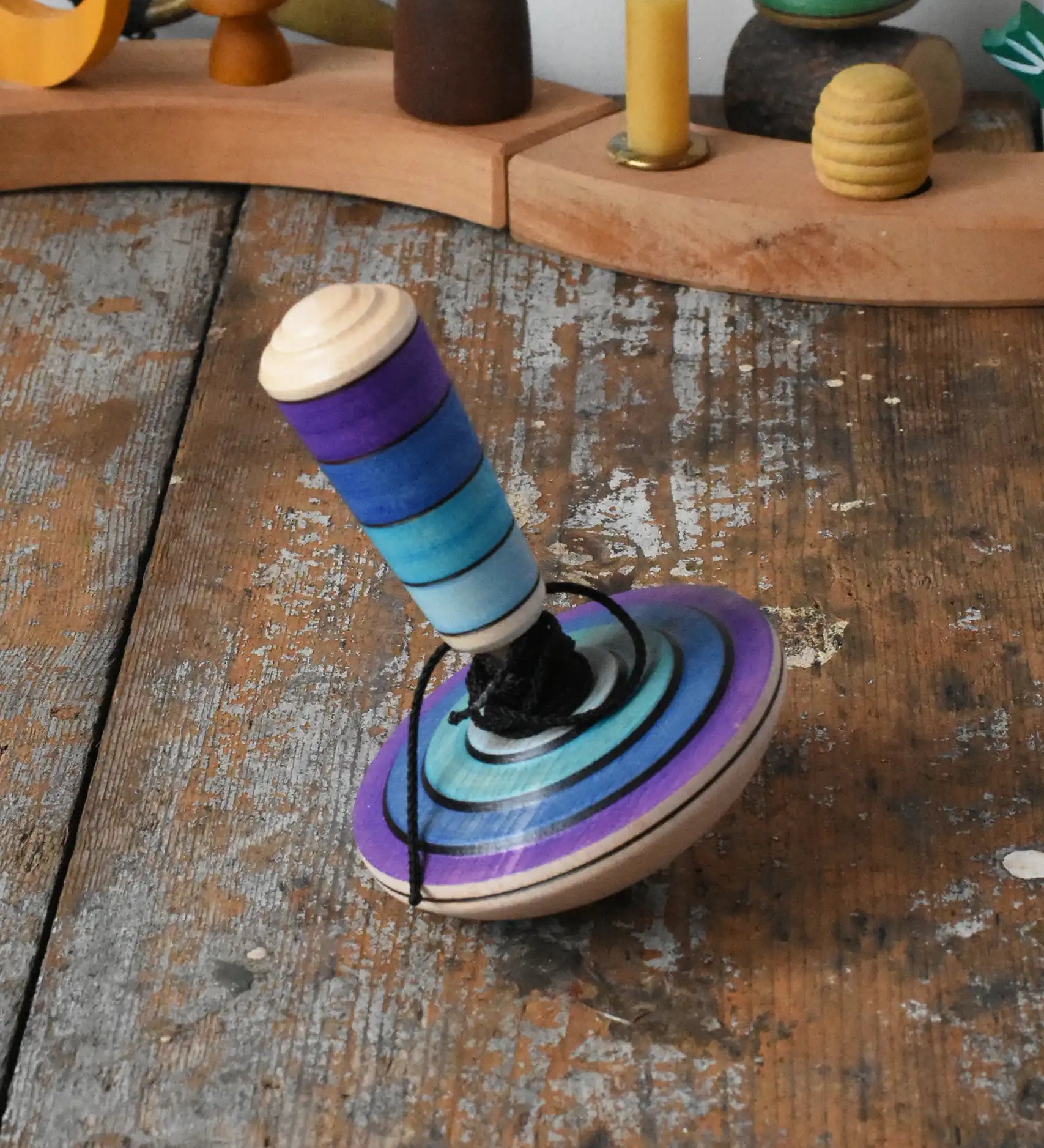 Mader my first spinning top toy with starter in purple placed on a wooden surface in the Babipur playroom. 