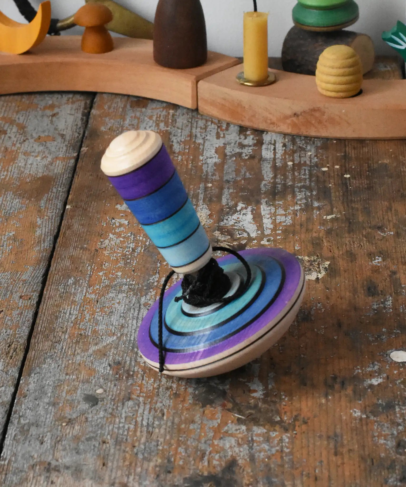 Mader my first spinning top toy with starter in purple placed on a wooden surface in the Babipur playroom. 