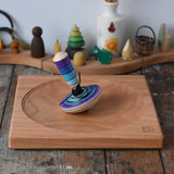 Mader my first spinning top toy with starter in purple placed on a large cherry spinning plate in the Babipur playroom. 
