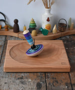 Mader my first spinning top toy with starter in purple placed on a large cherry spinning plate in the Babipur playroom. 