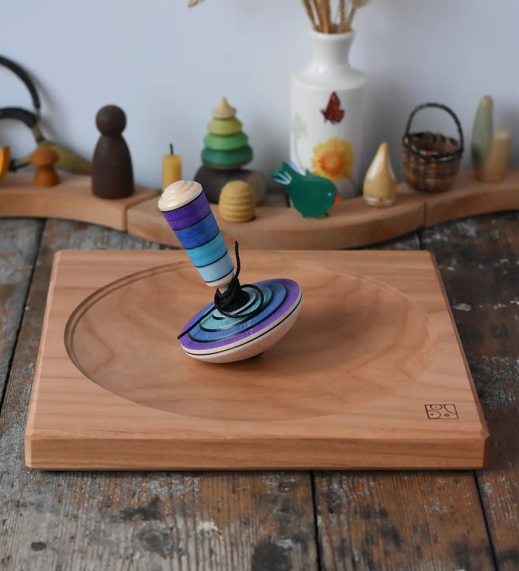Mader my first spinning top toy with starter in purple placed on a large cherry spinning plate in the Babipur playroom. 