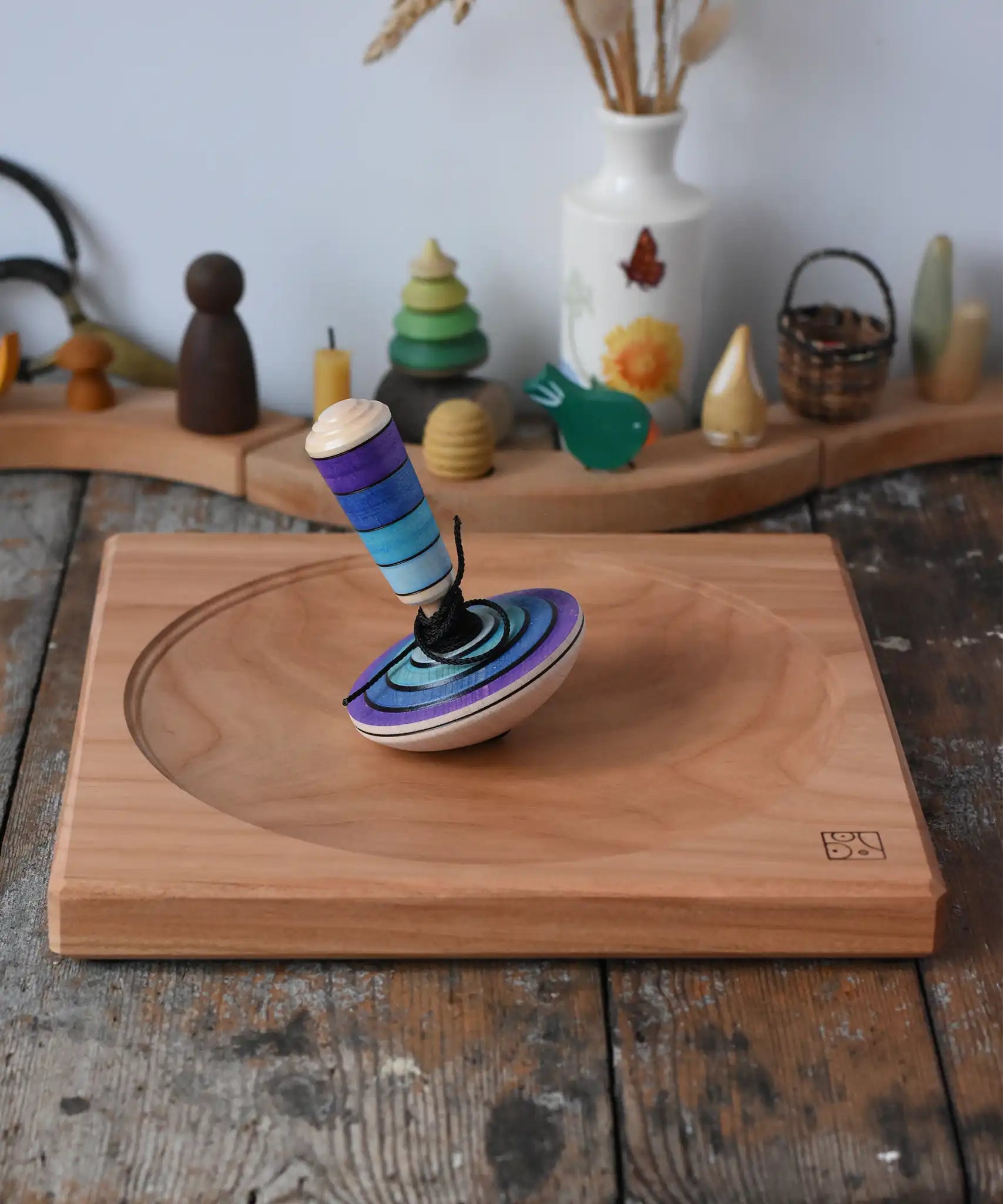 Mader my first spinning top toy with starter in purple placed on a large cherry spinning plate in the Babipur playroom. 