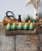 Mader Kreiselmanufaktur 5 tree spinning tops on branch placed on a wooden desk in the Babipur playroom.