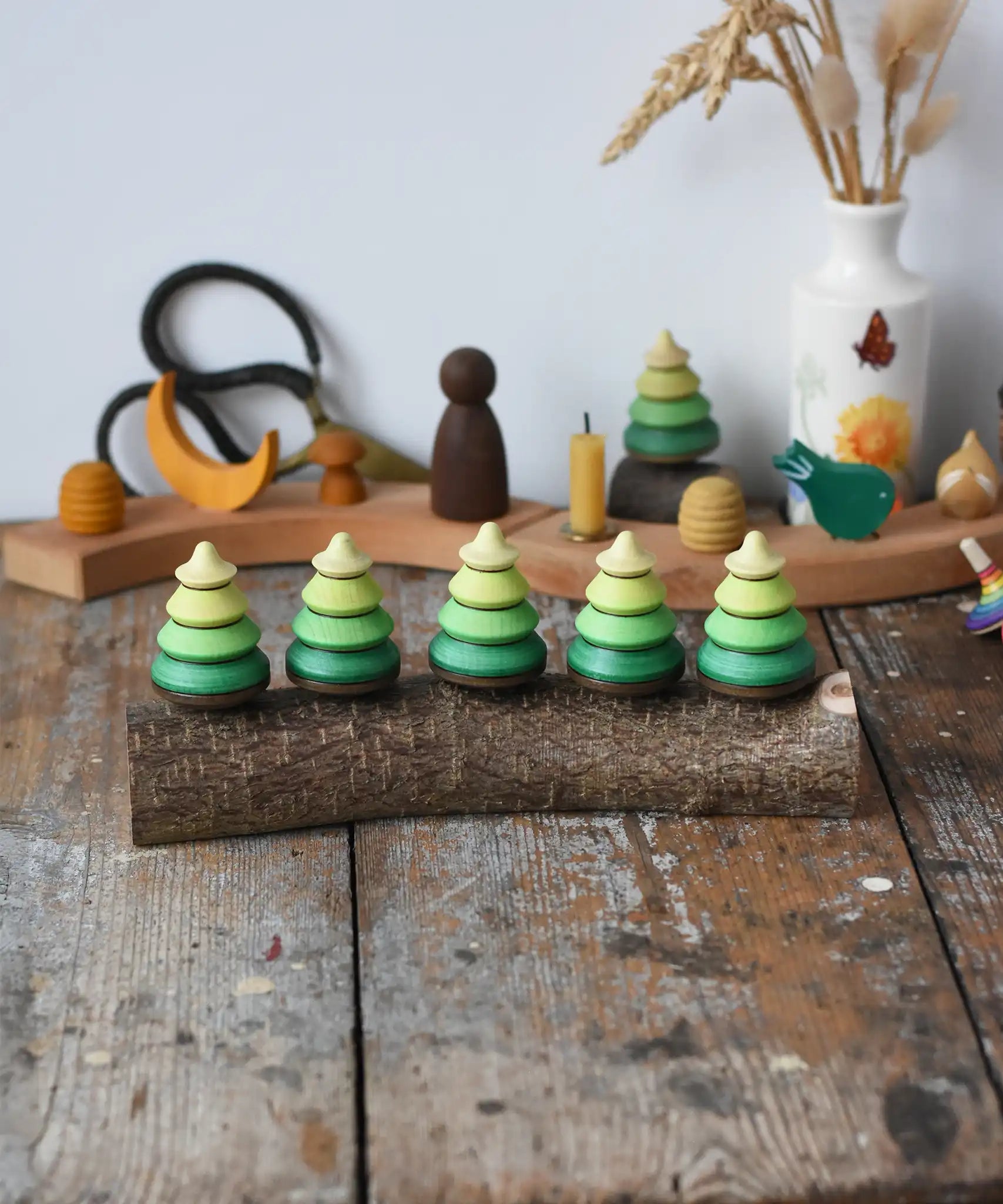 Mader Kreiselmanufaktur 5 tree spinning tops on branch placed on a wooden desk in the Babipur playroom.