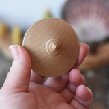 Bottom of the Mader flamenco spinning top in an adult's hand