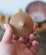 Bottom of the Mader flamenco spinning top in an adult's hand