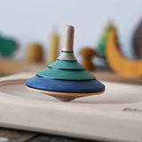 Mader flamenco spinning top spinning in motion in a maple spinning plate.
