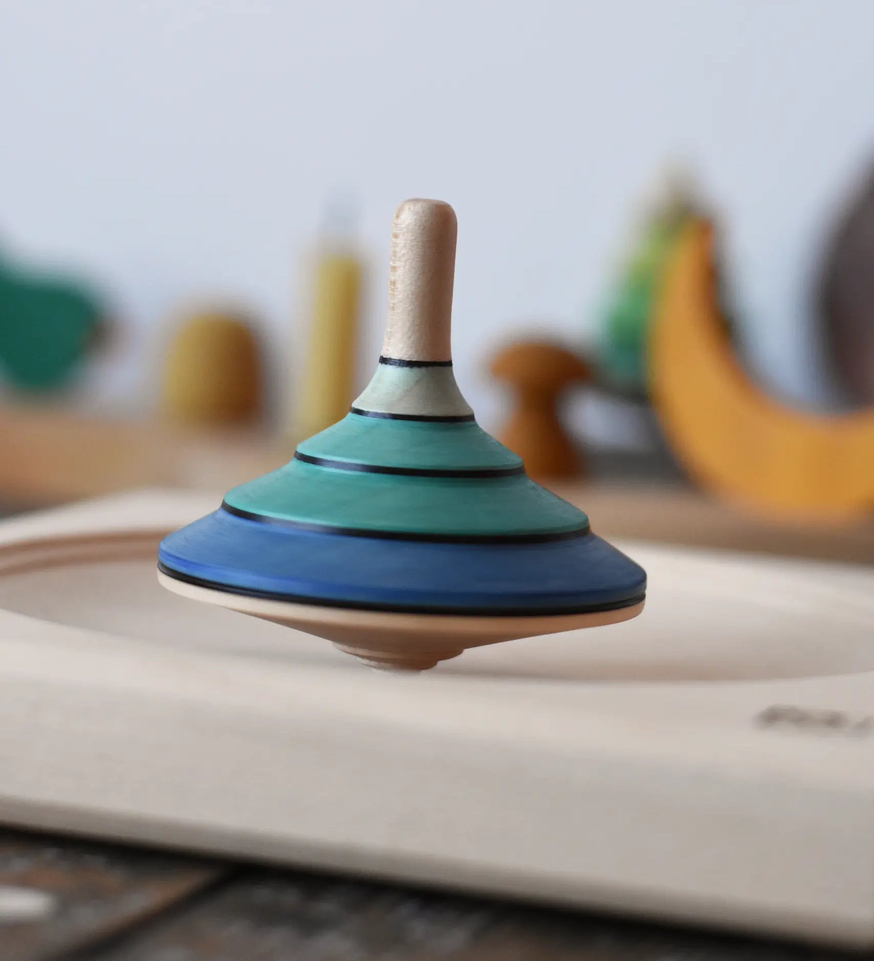 Mader flamenco spinning top spinning in motion in a maple spinning plate.