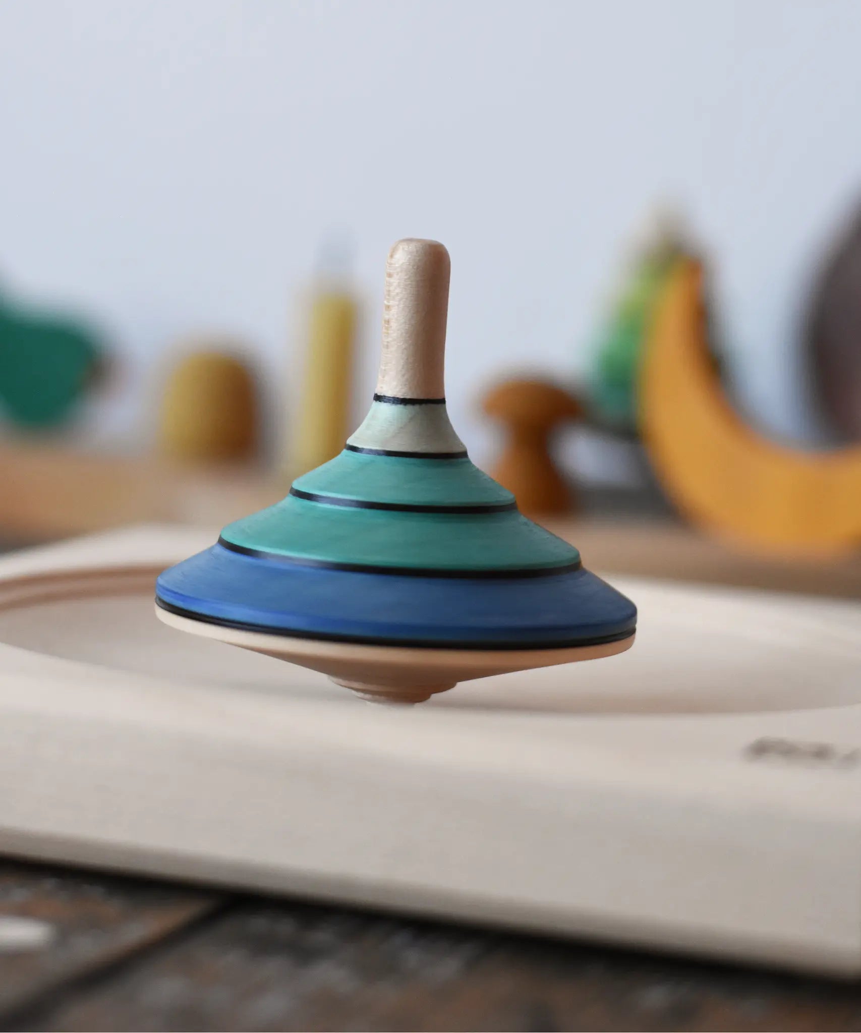 Mader flamenco spinning top spinning in motion in a maple spinning plate.