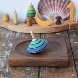 Mader flamenco spinning top placed on a walnut spinning plate in the Babipur playroom.