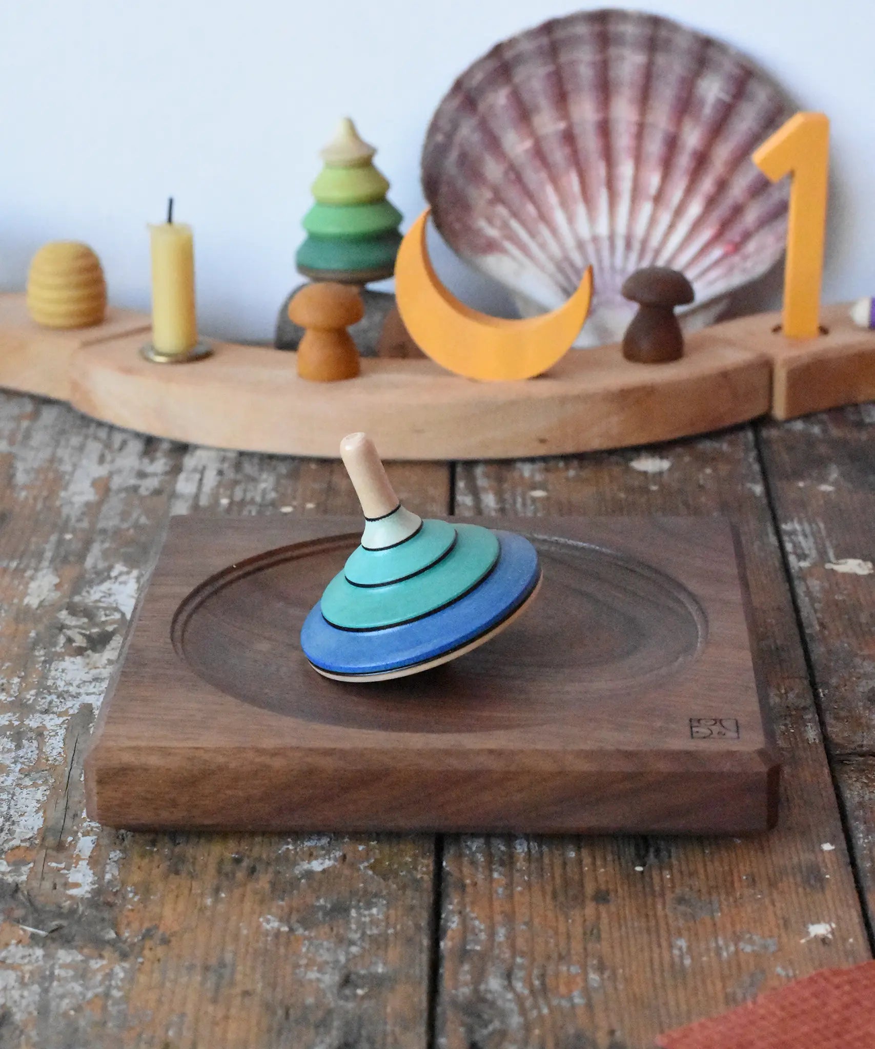 Mader flamenco spinning top placed on a walnut spinning plate in the Babipur playroom.