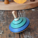 Mader flamenco spinning top placed on a wooden surface in the Babipur playroom.