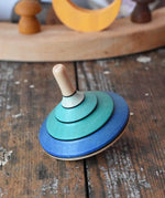 Mader flamenco spinning top placed on a wooden surface in the Babipur playroom.