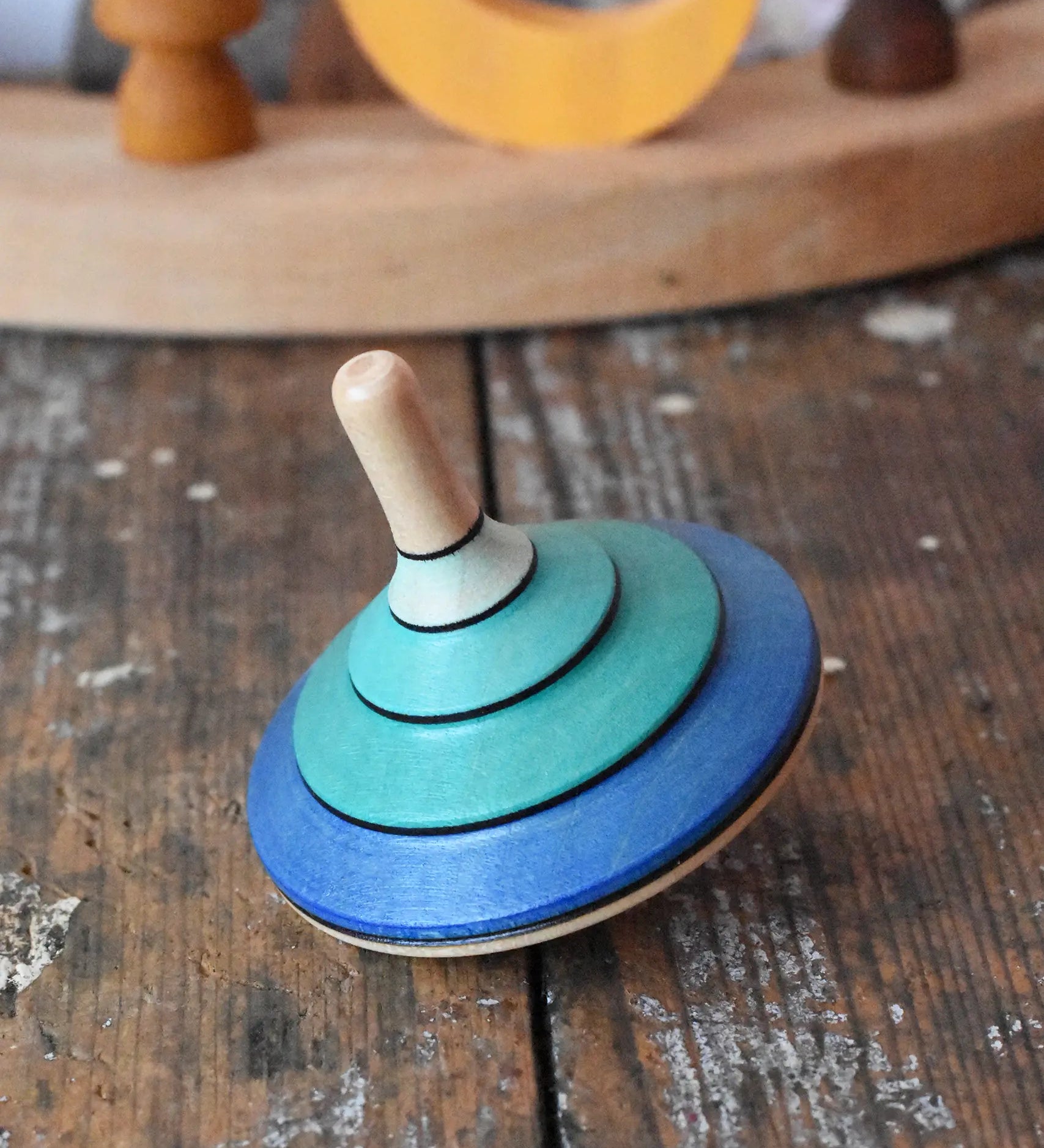 Mader flamenco spinning top placed on a wooden surface in the Babipur playroom.