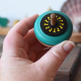 Mader flower egg spinning top in an adult's hand.