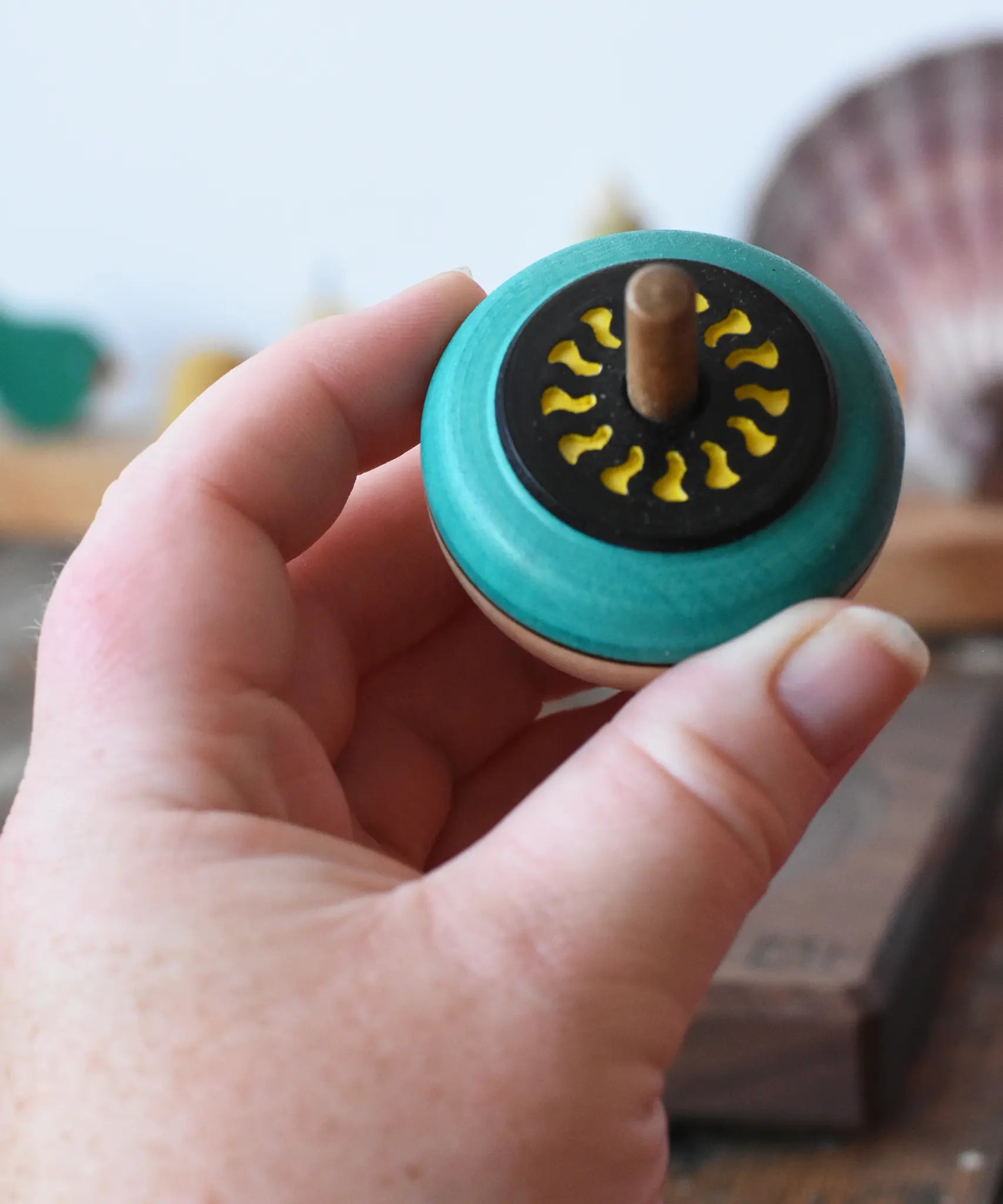 Mader flower egg spinning top in an adult's hand.