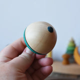 Bottom of the Mader flower egg spinning top in an adult's hand.