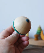 Bottom of the Mader flower egg spinning top in an adult's hand.