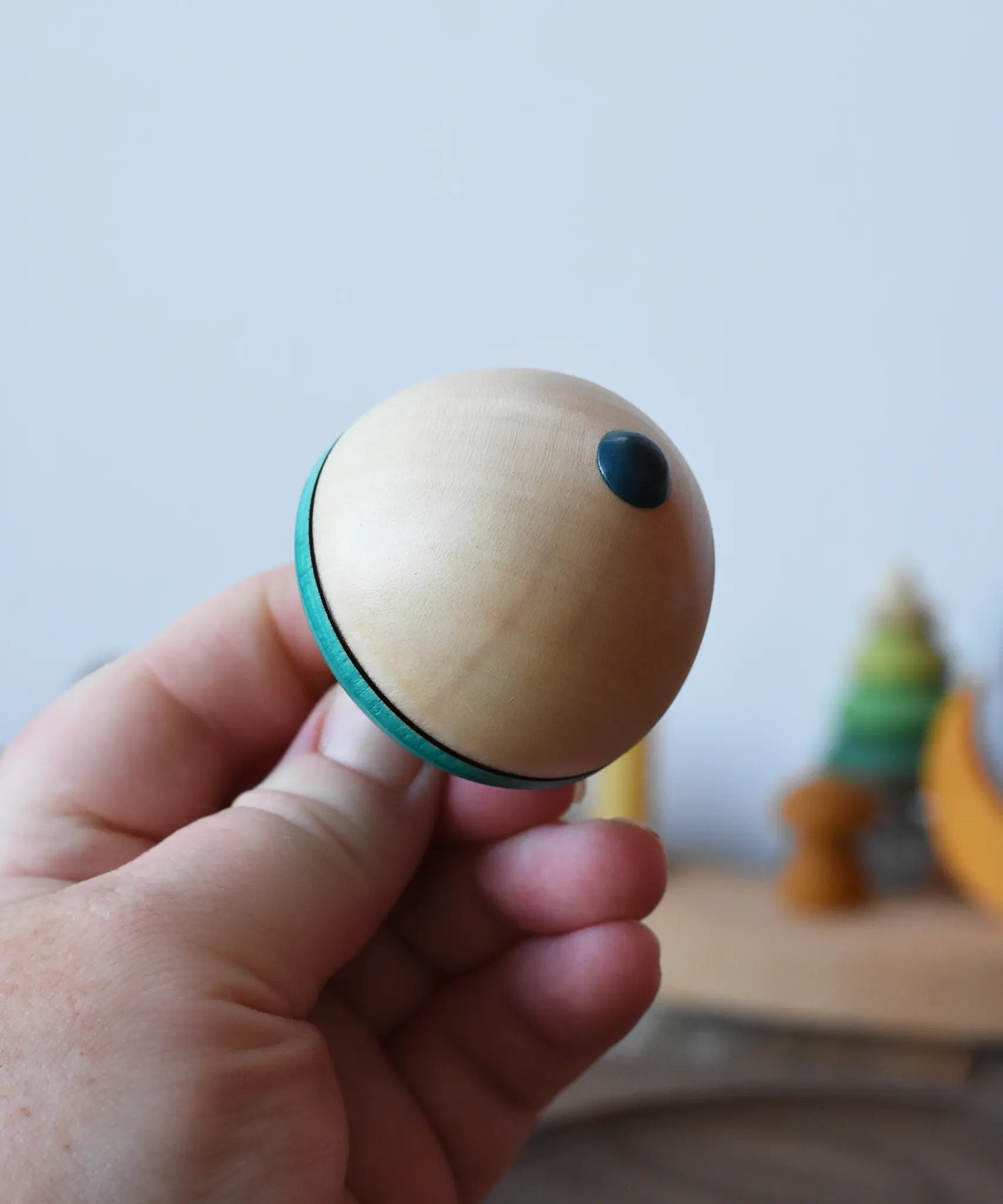 Bottom of the Mader flower egg spinning top in an adult's hand.