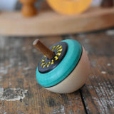 Mader flower egg spinning top placed on a wooden surface in the Babipur playroom.