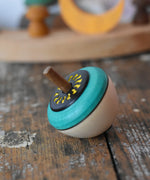 Mader flower egg spinning top placed on a wooden surface in the Babipur playroom.