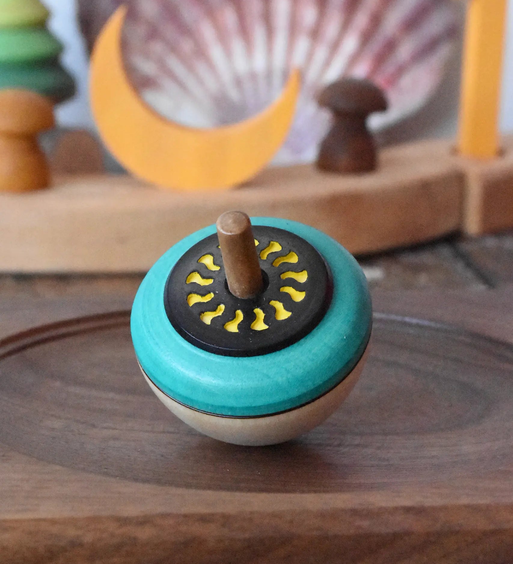 Mader flower egg spinning top placed on a medium walnut spinning plate in the Babipur playroom.