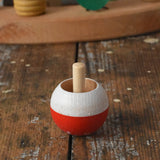 Mader Kreiselmanufaktur fly agaric mushroom turn over spinning top placed on a wooden desk in the Babipur playroom.