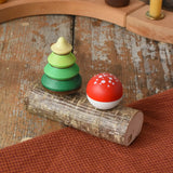 Mader Kreiselmanufaktur forest spinning top set. Green tree spinner and fly agaric mushrrom turn over top that sit on branch with two slots.