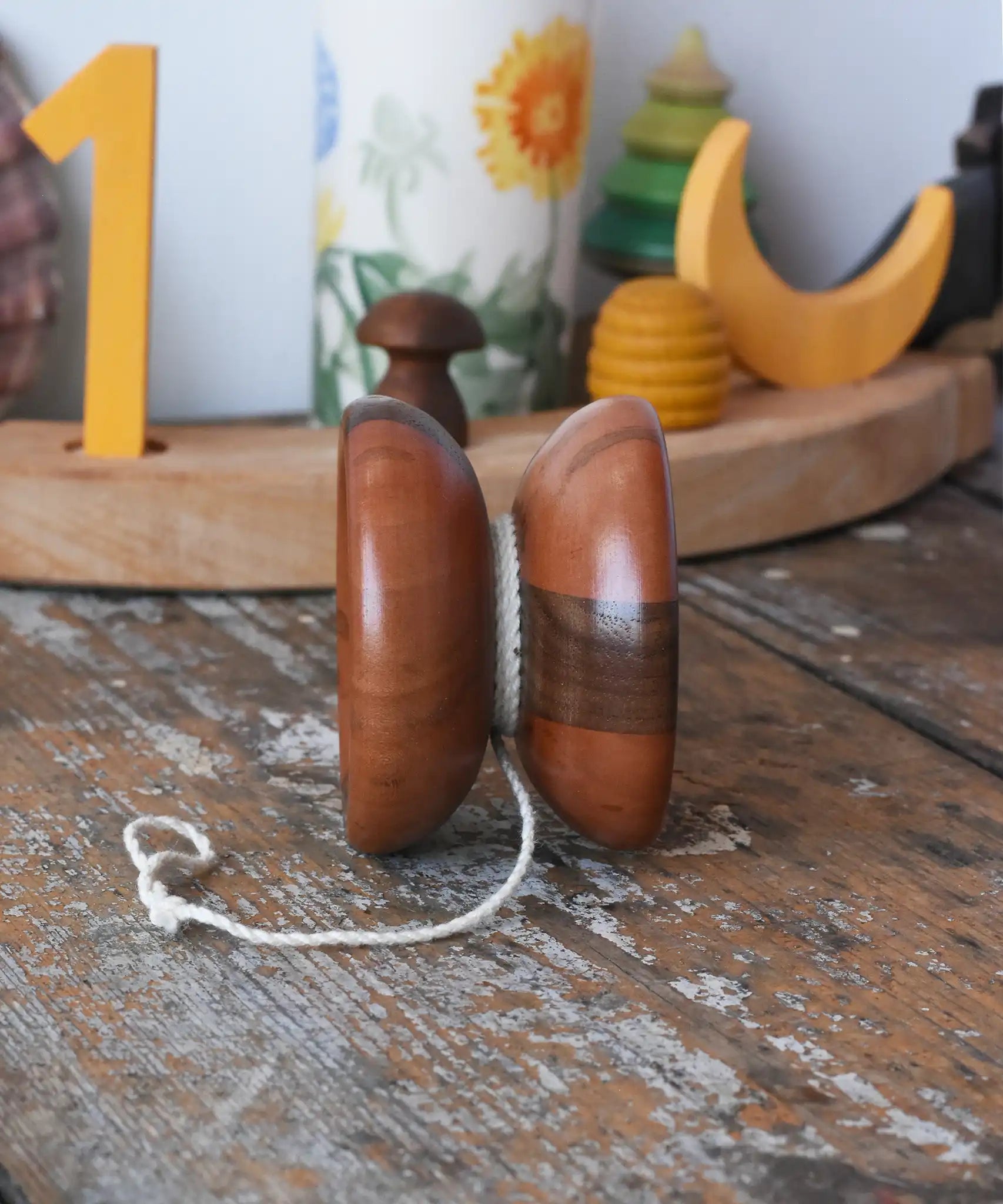 View of centre of the Mader free wheel butterfly yoyo placed on a wooden surface in the Babipur playroom. 