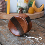 Mader free wheel butterfly yoyo placed on a wooden surface in the Babipur playroom. Walnut and pear wood toy. 