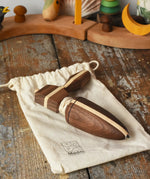 Mader goliath thunderbolt wooden spinning top with starter in a dark wood placed on a cotton drawstring storage bag in the Babipur playroom.