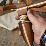 Mader goliath thunderbolt wooden spinning top with starter in an adult's hand in the Babipur playroom.