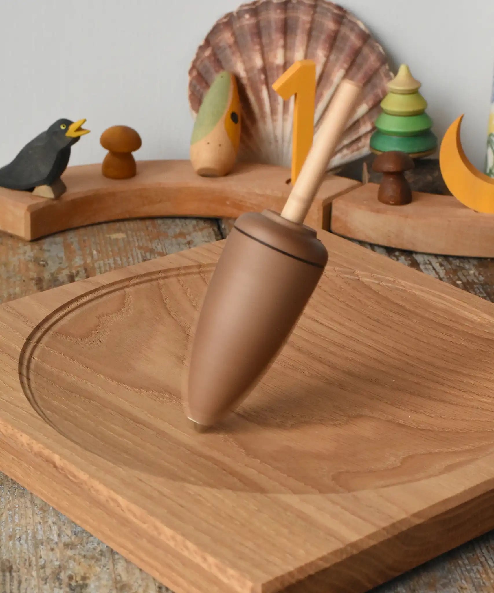 Mader goliath thunderbolt wooden spinning top spinning in motion on an oak spinning plate in the Babipur playroom.